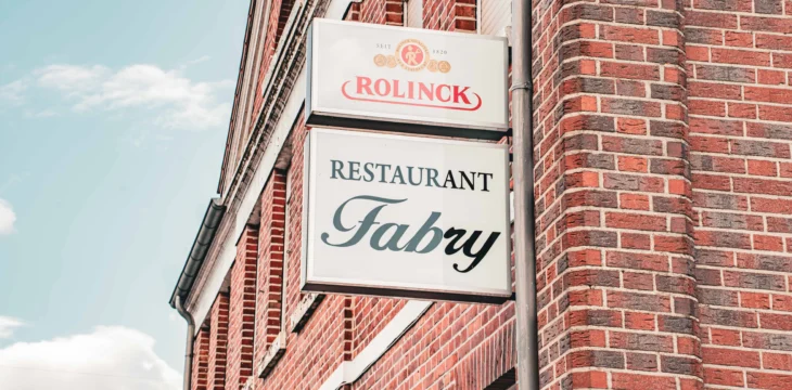 Schild mit der Aufschrift „Restaurant Fabry“ an der Fassade.