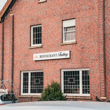 Außenansicht eines Backsteingebäudes mit Restaurantschild.