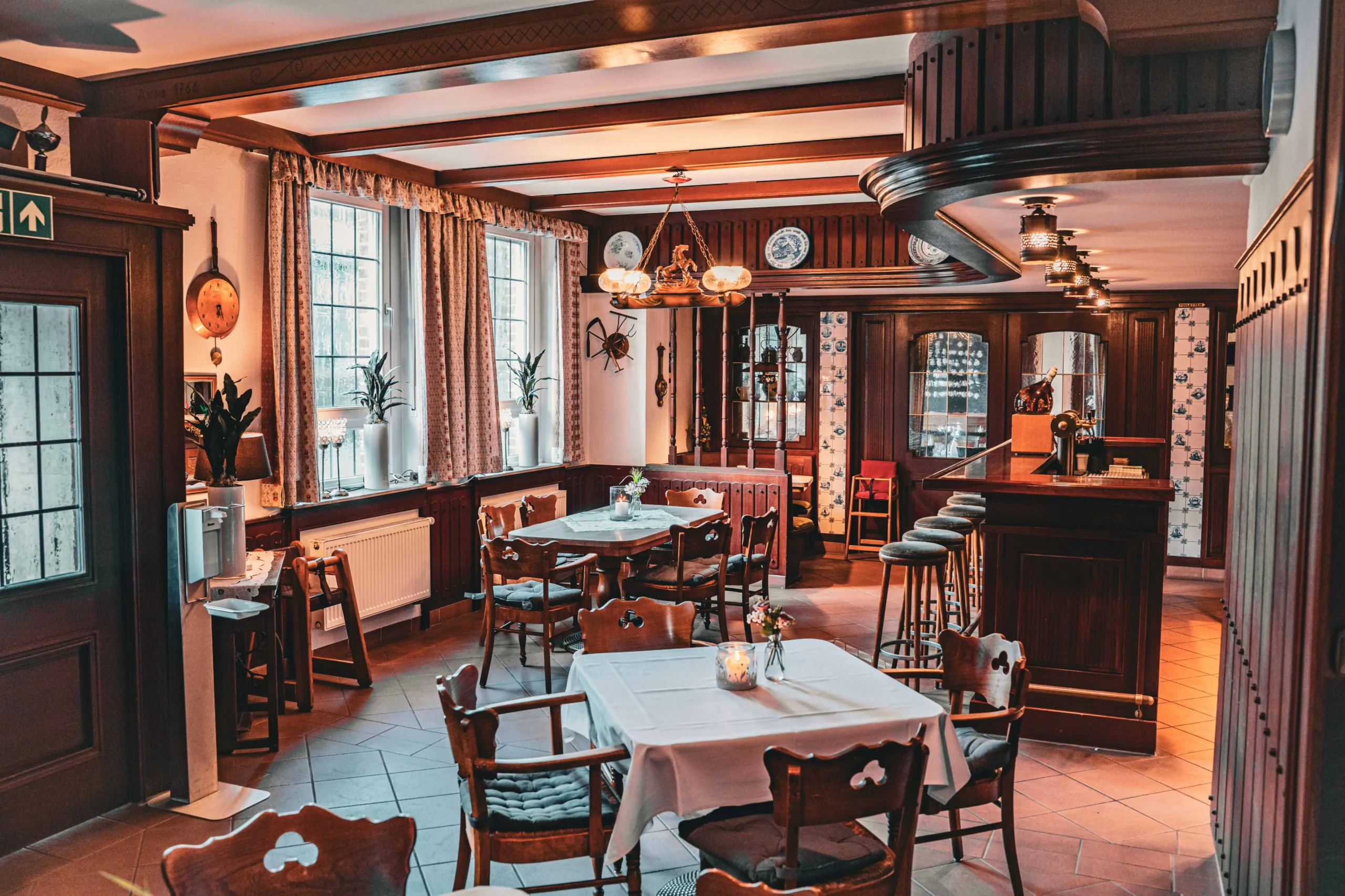 Gastraum mit eingedeckten Tischen und Bar.