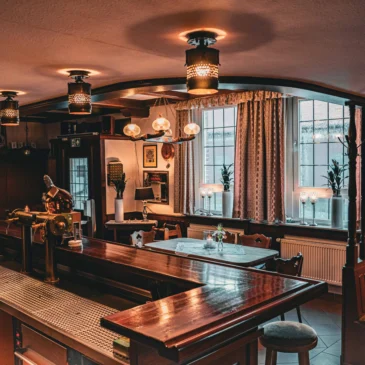 Blick von der Bar auf den Gastraum mit Tischen.